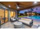 Inviting backyard patio featuring comfortable lounge seating, a ceiling fan, and a view of the pool and landscaped yard at 10658 E Cinnabar Ave, Scottsdale, AZ 85258