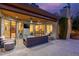 Stylish outdoor patio with stone accents, a ceiling fan, comfortable seating, and glass doors leading to interior spaces at 10658 E Cinnabar Ave, Scottsdale, AZ 85258