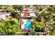 Aerial view of a backyard with a sparkling pool, patio seating, and lush greenery surrounded by towering palm trees at 10658 E Cinnabar Ave, Scottsdale, AZ 85258