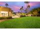 Lush backyard with a well-maintained lawn, palm trees, a pool, gazebo, and ample space for outdoor activities and relaxation at 10658 E Cinnabar Ave, Scottsdale, AZ 85258