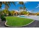 Expansive backyard with pool, cabana, lush lawn, and mature palm trees, creating a serene oasis at 10658 E Cinnabar Ave, Scottsdale, AZ 85258
