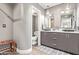 Modern bathroom with a double sink vanity, gray wood cabinets, mosaic tile accent wall, and a separate toilet room at 10658 E Cinnabar Ave, Scottsdale, AZ 85258