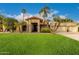 Inviting single-story home with a red tile roof, two-car garage, palm trees and lush green lawn at 10658 E Cinnabar Ave, Scottsdale, AZ 85258