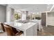 Modern kitchen featuring a large island with a cooktop, stone floors, and ample cabinet space at 10658 E Cinnabar Ave, Scottsdale, AZ 85258