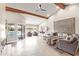 Open-concept living room with stone floors, vaulted ceiling, and a view of the inviting backyard pool at 10658 E Cinnabar Ave, Scottsdale, AZ 85258