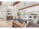 Bright living room with vaulted ceilings, wood beams, fireplace, and access to the outdoor patio at 10658 E Cinnabar Ave, Scottsdale, AZ 85258