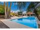 Beautiful pool with travertine deck, pergola, and outdoor lounge area, perfect for entertaining guests at 10658 E Cinnabar Ave, Scottsdale, AZ 85258