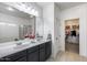 Bright bathroom with double sinks, tub, shower, and a walk-in closet at 12107 N 66Th Ave, Glendale, AZ 85304