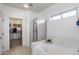 Well-lit bathroom featuring a tub, a shower, and a walk-in closet for ample storage at 12107 N 66Th Ave, Glendale, AZ 85304