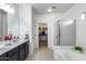 A modern bathroom offers double sinks, a tub, and a shower, along with a walk-in closet at 12107 N 66Th Ave, Glendale, AZ 85304
