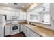 Well-lit kitchen with view to the dining area, with white appliances and cabinetry at 12107 N 66Th Ave, Glendale, AZ 85304