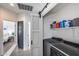Bright laundry room with sliding barn door, modern washer and dryer, and shelving at 12107 N 66Th Ave, Glendale, AZ 85304