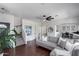 Bright living room featuring stylish gray sofa, ceiling fan, and staircase access at 12107 N 66Th Ave, Glendale, AZ 85304