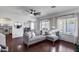 Bright living room boasts modern sectional sofa, dark wood floors, and neutral walls creating a cozy and inviting space at 12107 N 66Th Ave, Glendale, AZ 85304