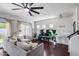 Open-concept living room with a large gray sectional, dark hardwood floors, and ample natural light at 12107 N 66Th Ave, Glendale, AZ 85304