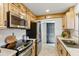 Renovated kitchen featuring wood cabinets, stainless steel appliances, and stylish tile backsplash at 13621 N 98Th Ave # E, Sun City, AZ 85351