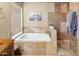 Bright bathroom with a soaking tub, tiled shower, and decorative art at 14247 N 2Nd Ave, Phoenix, AZ 85023