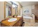 Well-lit bathroom featuring dual sinks, vanity, soaking tub, and stylish decor at 14247 N 2Nd Ave, Phoenix, AZ 85023