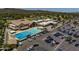 Community center featuring a large swimming pool, spacious parking area, and attractive building design at 14247 N 2Nd Ave, Phoenix, AZ 85023