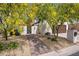 Charming home entrance with a beautiful yellow flowering tree and a brick walkway leading to the front gate at 14247 N 2Nd Ave, Phoenix, AZ 85023