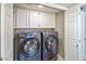 A laundry room featuring a modern washer and dryer and white cabinets for plenty of storage at 14247 N 2Nd Ave, Phoenix, AZ 85023