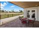 A covered patio featuring outdoor furniture with a view of the grassy golf course beyond the fence at 14247 N 2Nd Ave, Phoenix, AZ 85023