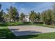 Community basketball court surrounded by lush green grass and mature trees on a sunny day at 14870 W Encanto Blvd # 2123, Goodyear, AZ 85395