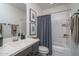 Bathroom featuring a single sink vanity with dark cabinets, a shower with blue curtain, and neutral decor at 14870 W Encanto Blvd # 2123, Goodyear, AZ 85395