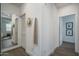 Bright hallway featuring light wood floors, mirror, and multiple doorways at 14870 W Encanto Blvd # 2123, Goodyear, AZ 85395