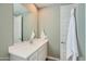 A stylish bathroom features a double sink vanity with sleek fixtures, a large mirror, and a decorative towel at 15782 W Kendall St, Goodyear, AZ 85338