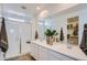 This bathroom features a glass shower, dual sinks, and decor plants on the bright countertop at 15782 W Kendall St, Goodyear, AZ 85338
