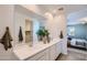 This primary bathroom shows dual sinks, white cabinets, and decor plants on the white countertop at 15782 W Kendall St, Goodyear, AZ 85338
