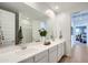 This primary bathroom shows dual sinks and white cabinets on the bright countertop and decor plants at 15782 W Kendall St, Goodyear, AZ 85338