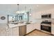Stylish kitchen with stainless steel appliances, an island with a sink, and an open layout to the living area at 15782 W Kendall St, Goodyear, AZ 85338