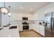Modern kitchen with stainless steel appliances, white cabinets, and a quartz countertop island at 15782 W Kendall St, Goodyear, AZ 85338