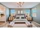 This main bedroom has decor lighting, white bedding, and bright light through the window at 15782 W Kendall St, Goodyear, AZ 85338