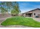 Lush backyard featuring manicured lawn, mature tree, patio, and privacy fence at 16103 W Redfield Rd, Surprise, AZ 85379