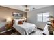 A warmly decorated bedroom featuring a comfortable bed, wood floors, and a picturesque window view at 16103 W Redfield Rd, Surprise, AZ 85379