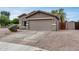 Inviting single-story house featuring a two-car garage and manicured desert landscaping under a bright blue sky at 16103 W Redfield Rd, Surprise, AZ 85379