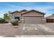 Charming single-story home features a two car garage, desert landscaping, and a welcoming facade under a blue sky at 16103 W Redfield Rd, Surprise, AZ 85379