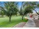 Community green space with a sidewalk path, lush grass, and playground at 16103 W Redfield Rd, Surprise, AZ 85379