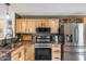 A well-organized kitchen with natural wood cabinets, granite countertops, and stainless steel appliances at 16103 W Redfield Rd, Surprise, AZ 85379