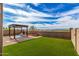 Lawn and pergola in an expansive backyard with views of mountains in the distance at 17532 W Copper Ridge Dr, Goodyear, AZ 85338