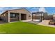 Well kept backyard with artificial turf and desert landscaping with view of the house at 17532 W Copper Ridge Dr, Goodyear, AZ 85338