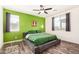 A vibrant bedroom with green accent wall, hardwood floors, and two windows that let in plenty of natural light at 17532 W Copper Ridge Dr, Goodyear, AZ 85338
