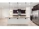 Well-lit kitchen features a granite-topped island with pendant lighting and stainless steel appliances at 17532 W Copper Ridge Dr, Goodyear, AZ 85338