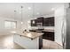 Kitchen with a granite-topped island, pendant lights, stainless steel appliances and a white-tiled floor at 17532 W Copper Ridge Dr, Goodyear, AZ 85338