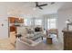 Inviting living room showcasing a comfortable seating area, a ceiling fan, and seamless access to the kitchen at 17532 W Copper Ridge Dr, Goodyear, AZ 85338