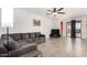 Spacious living room featuring neutral walls, tile flooring, ceiling fan, and sliding glass doors at 17532 W Copper Ridge Dr, Goodyear, AZ 85338