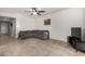 Spacious living room featuring a large sectional sofa, neutral tile flooring, and a ceiling fan for added comfort at 17532 W Copper Ridge Dr, Goodyear, AZ 85338
